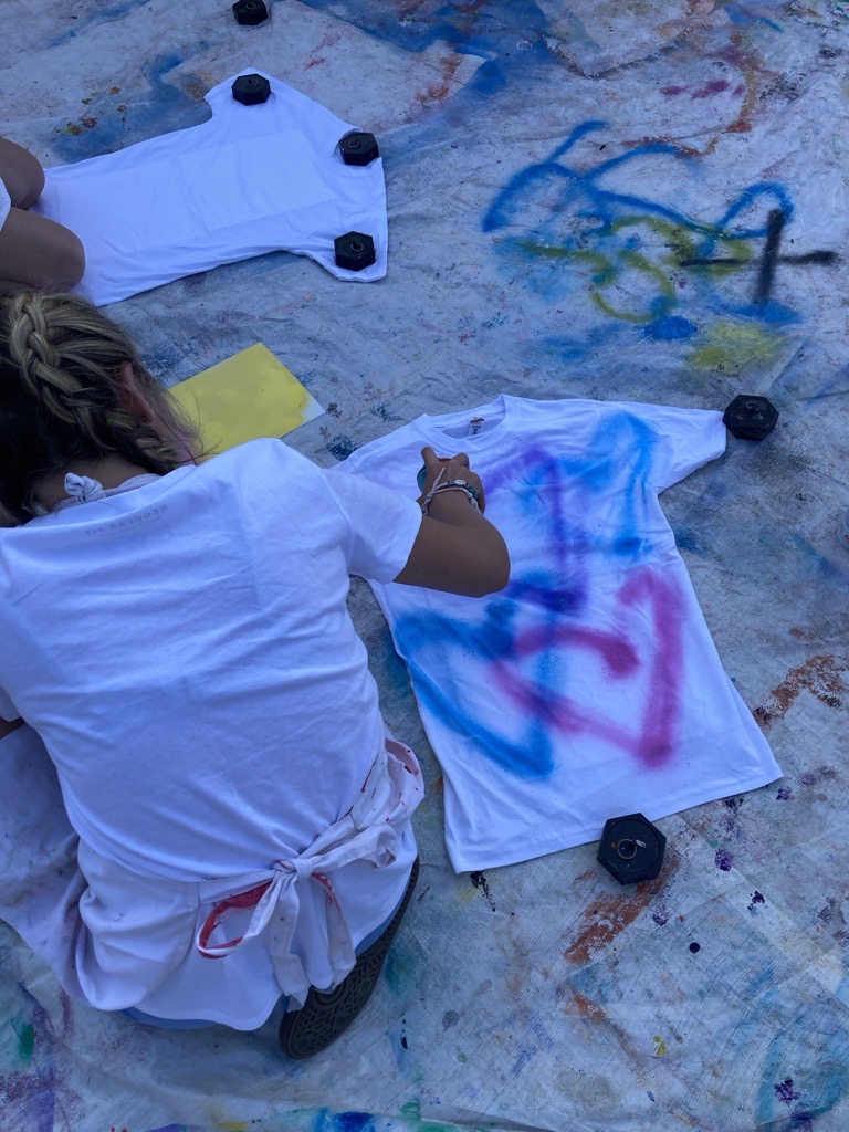 young girl painting hearts on a tshirt