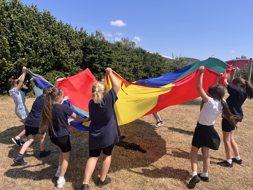 children playing in a field with a colourful blanket